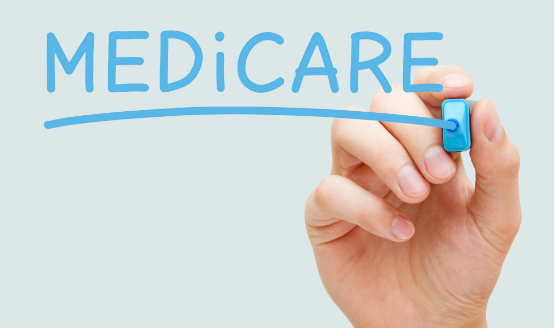 Hand with a marker writing Medicare on glass